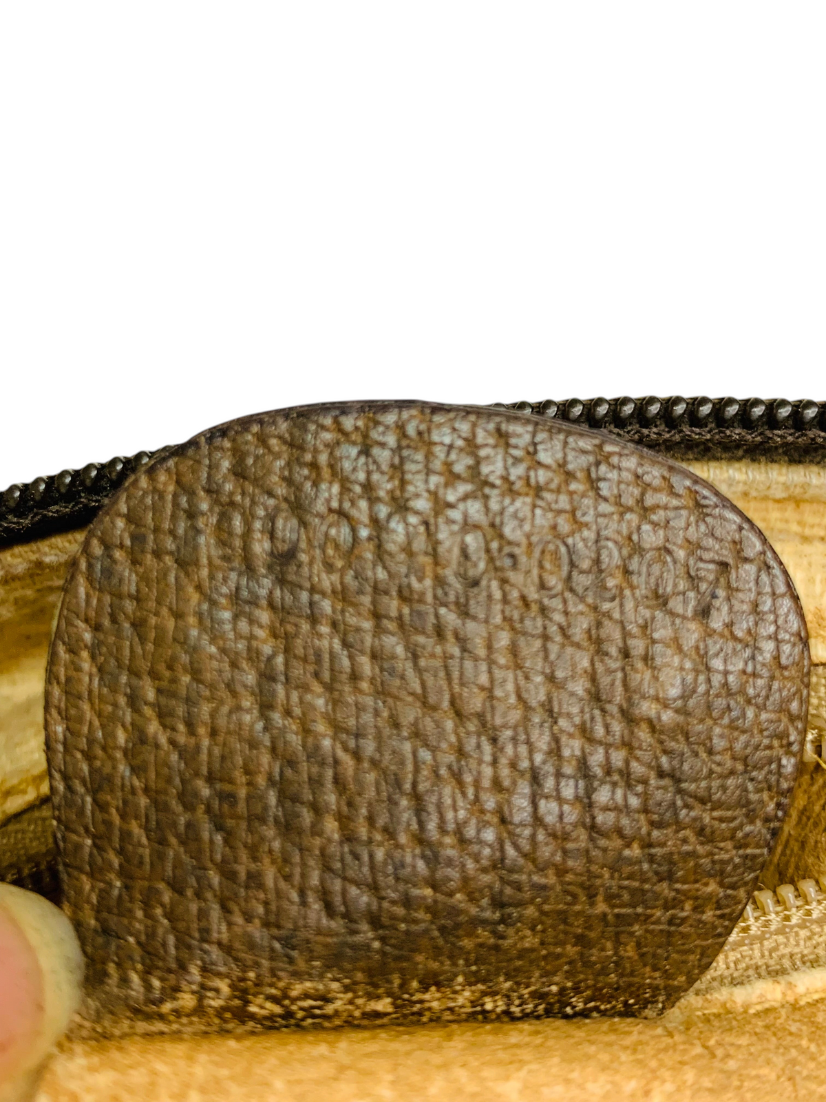 Cherry's Luxury Collection Gucci brown leather interior tag with embossed serial number detail.