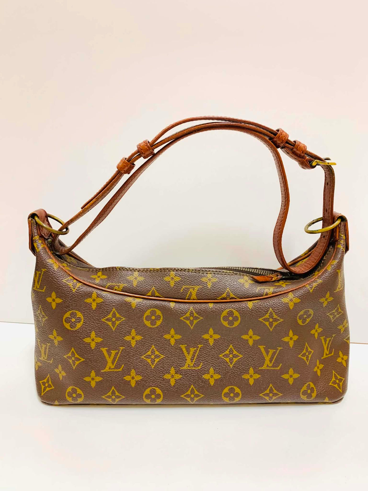 A Louis Vuitton monogram shoulder bag in brown coated canvas with yellow monogram motifs and a brown leather top handle, shown against a plain light background.