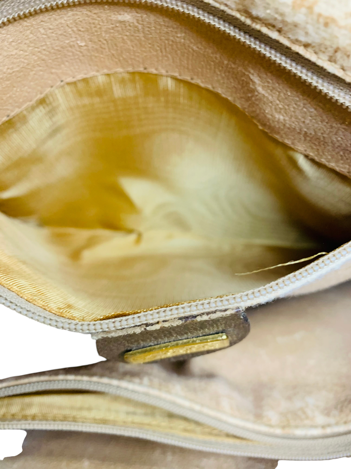 Interior of a beige Cherry's Luxury Collection Gucci handbag featuring a gold zipper and fabric lining.