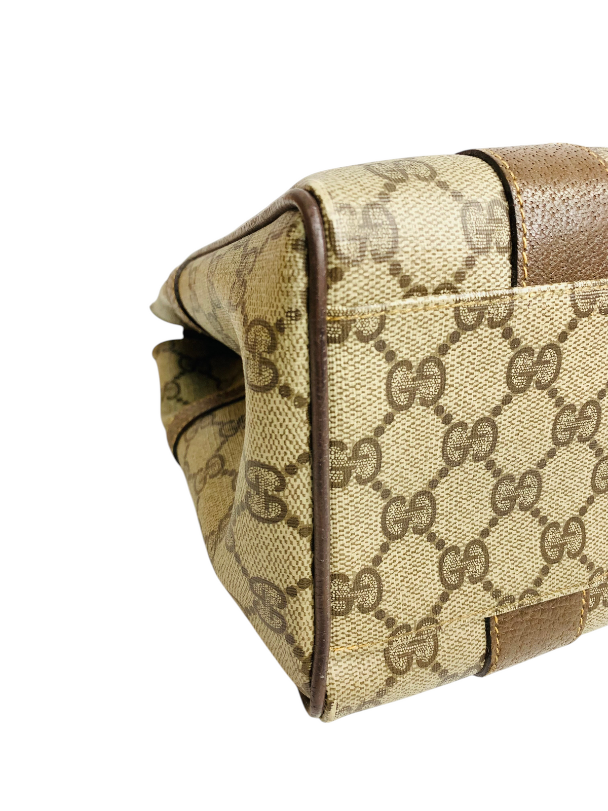 Cherry's Luxury Collection Gucci monogram canvas handbag side view with brown leather trim details.