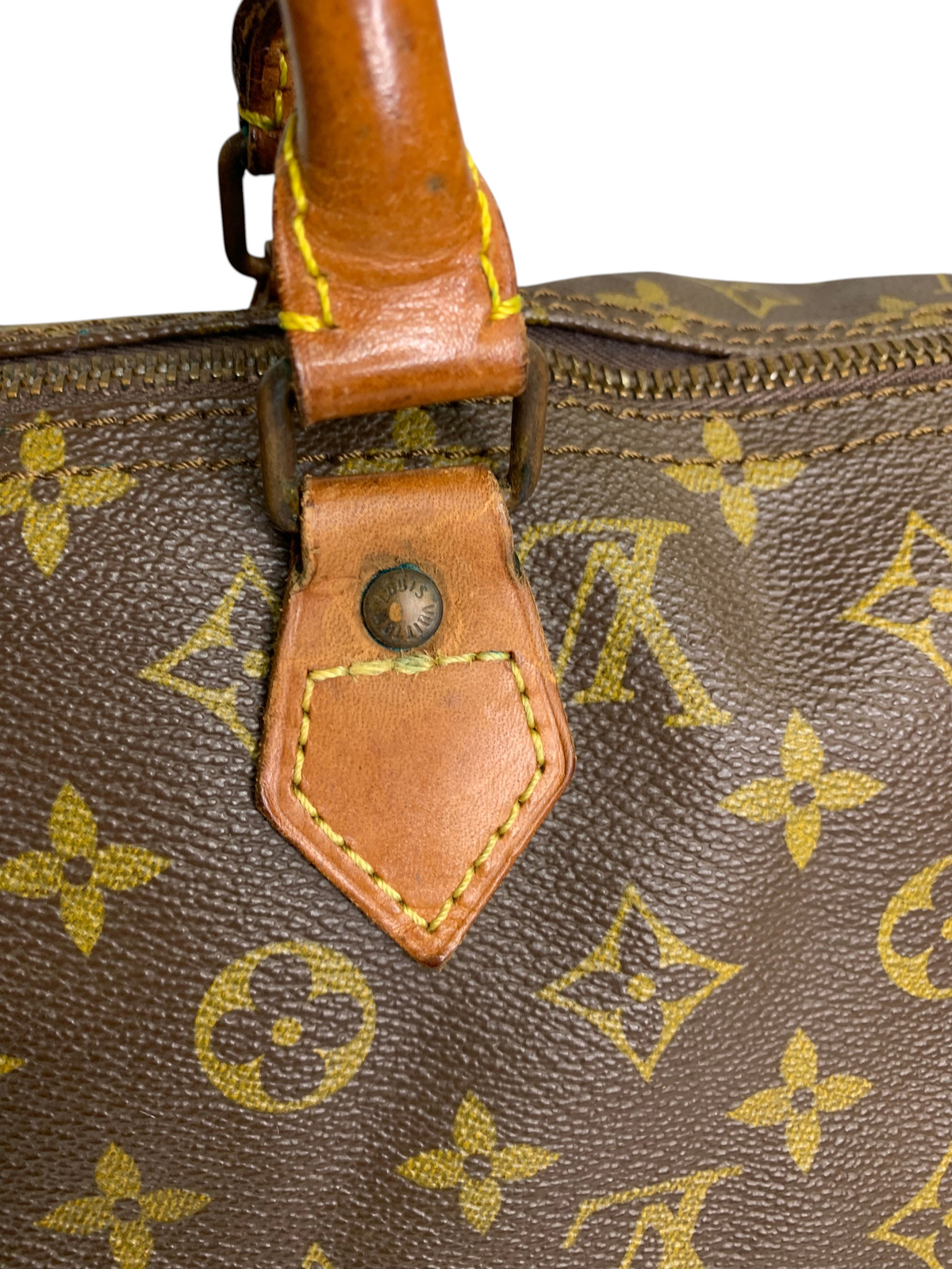 Louis Vuitton monogram coated canvas travel duffel bag with tan leather handle attachment and brass hardware detail.