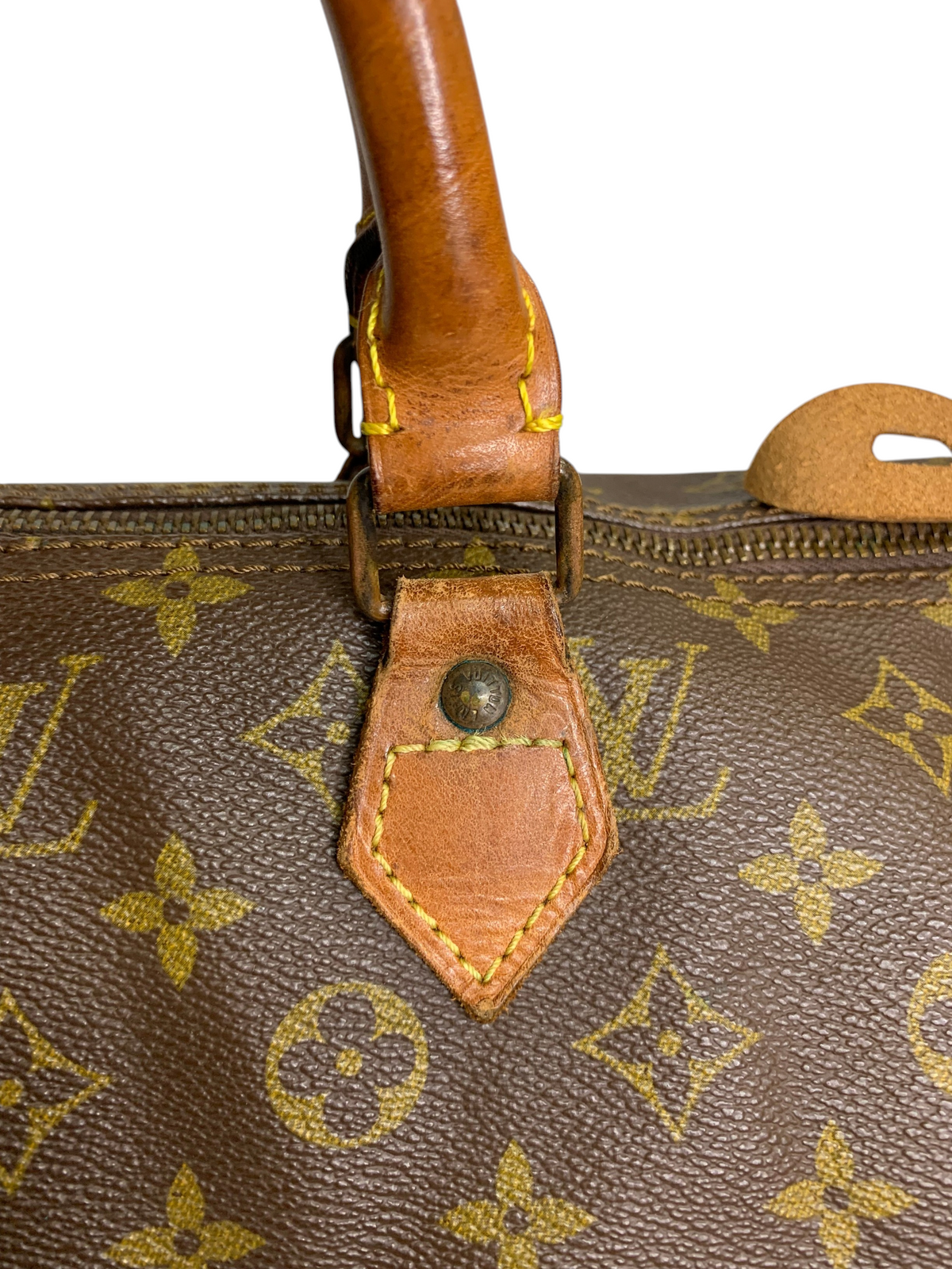 Louis Vuitton monogram coated canvas travel duffel bag with brown leather handle and brass hardware detail.