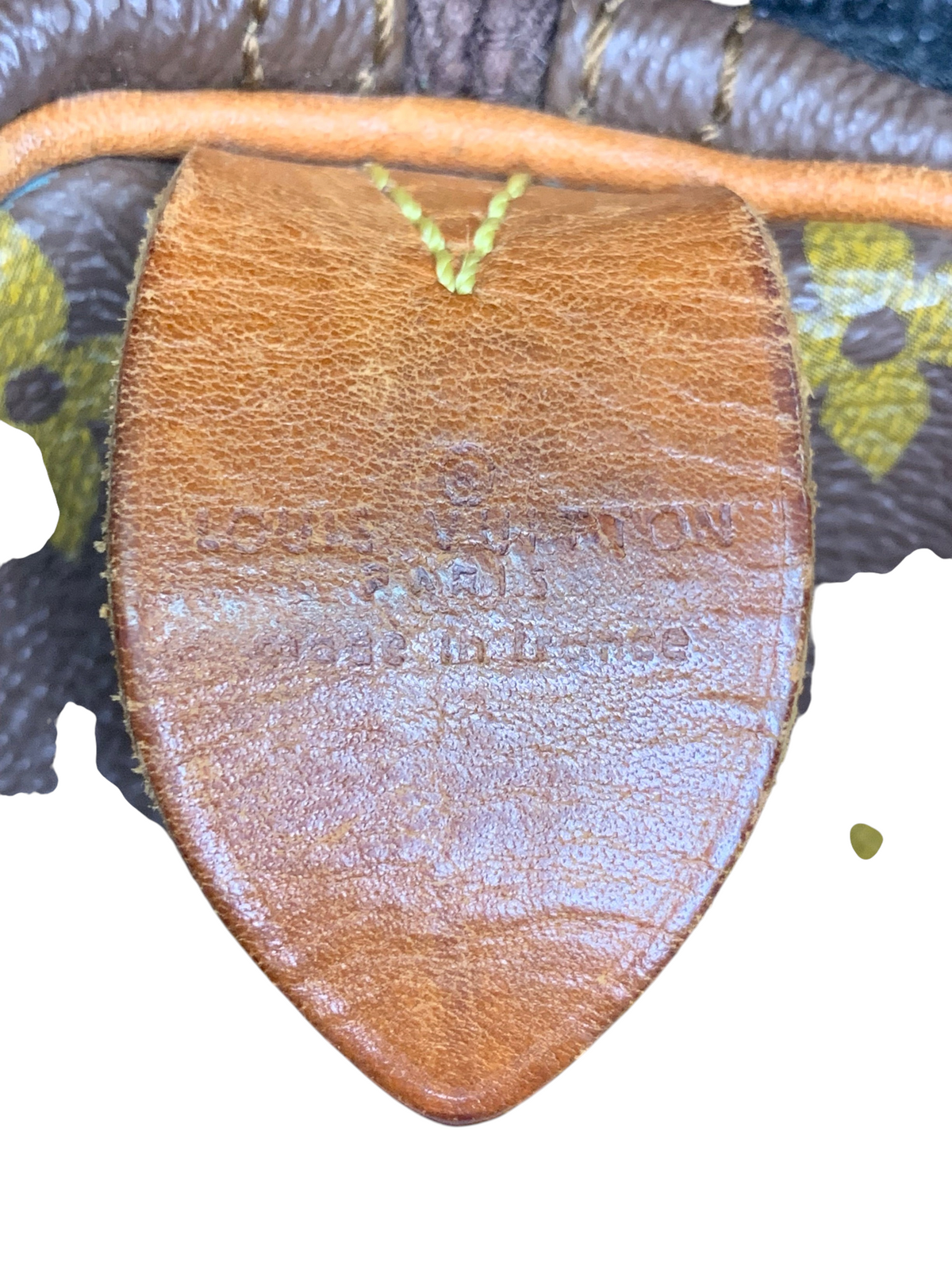 Louis Vuitton monogram canvas duffel bag leather tab with embossed brand logo and made in France stamp.